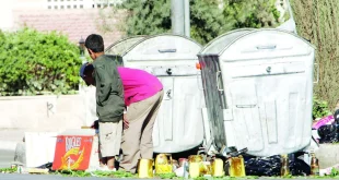 طفلان ينتشلون أغراضا من حاوية قمامة